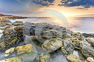 Surreal landscape heap of stones in the sea shot with a long exp