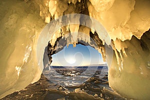 Surreal landscape with people exploring mysterious ice grotto cave. Outdoor adventure. Family exploring huge icy cave