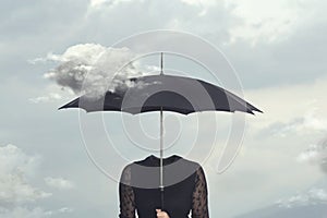 Surreal moment of a cloud caressing the umbrella of a headless woman photo