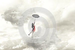 Surreal moment of an elegant woman flying in the middle of the clouds hanging on her umbrella