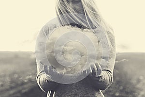 A surreal moment, solitary woman holding in her hands a grey cloud photo