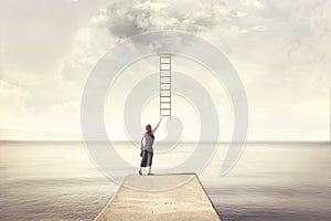 Surreal moment of woman climbing an imaginary scale to the clouds