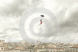 Surreal moment of a woman flying with her umbrella over the city