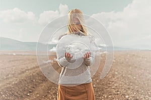 Surreal moment of a woman holding a cloud in her hands photo