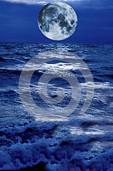 Surreal moon hovering above blue stormy water