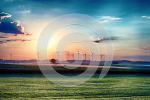 Surreal morning sunrise on the fields with wind turbines in the background