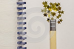 Surreal paint brush drawing golden stars confetti. Artistic concept on sketchbook background