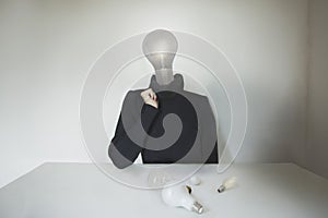 Surreal person with light bulb instead of head has a doubt about his idea; concept of choice, creativity, doubt; idea, technology