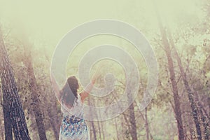 Surreal photo of young woman standing in forest. image is textured and toned. dreamy concept