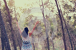 Surreal photo of young woman standing in forest. image is textured and toned. dreamy concept.