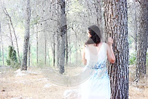 Surreal photo of young woman standing in forest. natural light. dreamy concept.