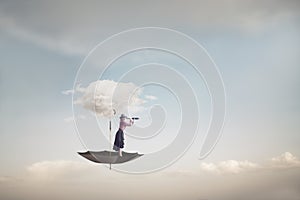 surreal umbrella carried by a cloud takes a woman to the sky, abstract concept