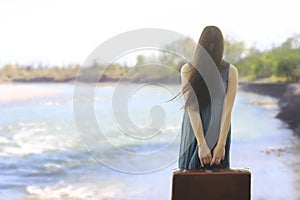 Surreal woman with suitcase and face covered by her hair begins her journey towards the future