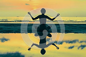 Surreal yoga silhouette of woman on the Sea beach. Relax.