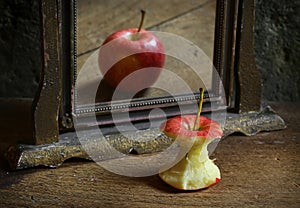 Surrealistic image with apple reflecting in the mirror.