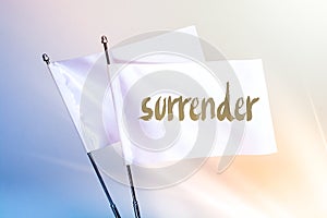 SURRENDER wording written on white flag in display