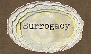 Surrogacy - typewritten word in ragged paper hole background