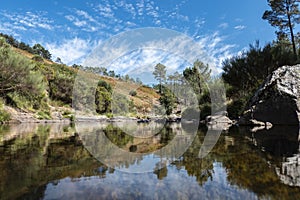 Surrounded by a mountain and a blue sky and a stream of water