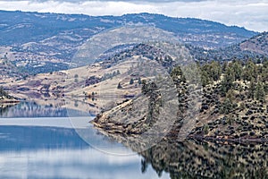 The surrounding hills and forest are reflected in the reservoir at the Iron Gate Dam near Hornbrook , California, USA