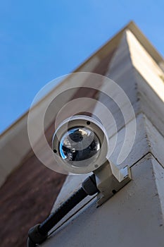 Surveillance camera mounted on the facade of a tall, modern building in Manhattan, New York City, USA