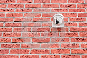 Surveillance camera mounted on red brick wall