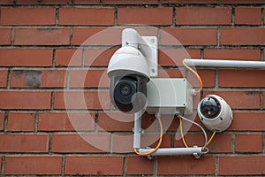 Surveillance camera system on a red brick wall, modern security technology collects video material of surrounding incidents to