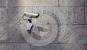 Surveillance CCTV Security Camera on stone wall building facade