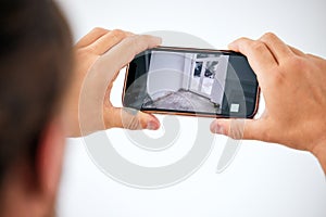 Surveillance, cctv and smartphone screen in hands for door monitor on wall mock up for trust, safety and home insurance