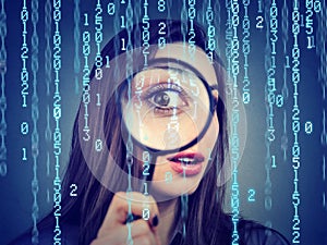 Surveillance of cyber crime concept. Curious woman looking through a magnifying glass and computer binary code background