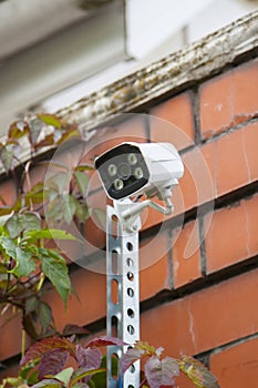 Surveillance and safety home concept. Security CCTV camera monitoring perimeter of private house in village