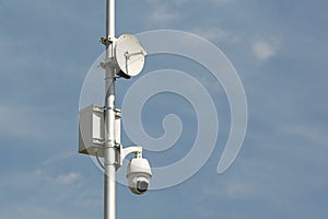 Surveillance system with an orange warning light located on a pole in the open. The threat of privacy and the protection of