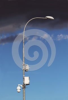 Surveillance system with an orange warning light located on a pole in the open. The threat of privacy and the protection of