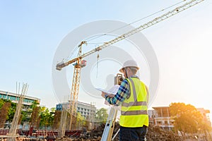 Surveying engineers are working together using theodolite on the construction site