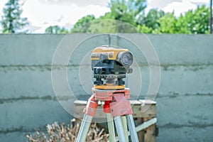Surveying measuring equipment level transit on tripod at construction building area site