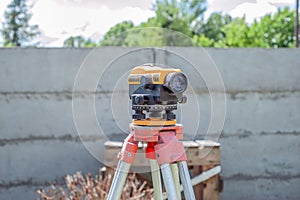 Surveying measuring equipment level transit on tripod at construction building area site