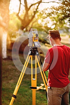 surveyor caucasian engineer working with total station theodolite at landscaping project