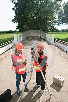 Surveyor or Engineer making measure with partner on the field.