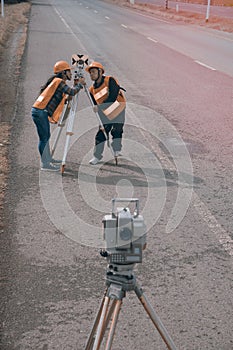 Surveyor or Engineer making measure with partner on the highway.