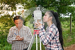 Surveyor or Engineer making measure by Theodolite in a field.