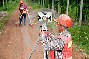 Surveyor or Engineer making measure by Theodolite in a field.