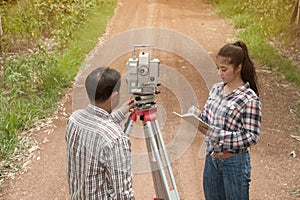 Surveyor or Engineer making measure by Theodolite with partner o