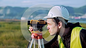 Surveyor engineer is measuring level on construction site. Geodesist ensure precise measurements before undertaking