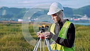 Surveyor engineer is measuring level on construction site. Geodesist ensure precise measurements before undertaking