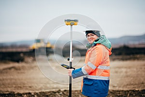 Surveyor engineer working on highway construction site, working with theodolite and gps system