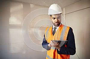 Surveyor In Hard Hat And High Visibility Jacket With Digital Tablet Carrying Out House Inspection