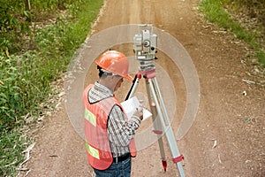 Surveyor making measure by Theodolite on the street.