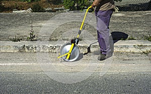 Surveyor with measuring wheel (odometer) detects the length of an excavation