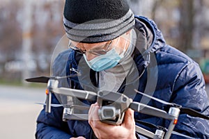 Surveyor in a protective mask prepares a quadcopter for flying around an object