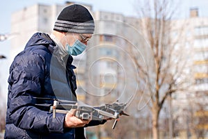 Surveyor in a protective mask prepares a quadcopter for photogrammetry