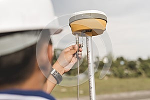 A surveyor sets up a Global Navigation Satellite System or GNSS Receiver. Real-time kinematic or RTK geodetic surveying equipment photo